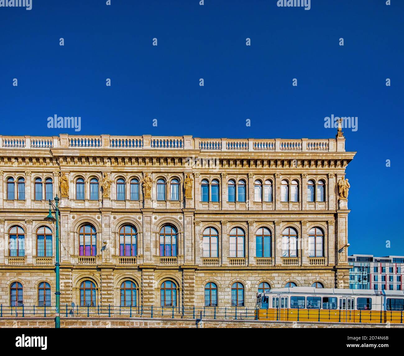 Budapest, Hungary, March 2020,  yellow tram passing by the building at 1-2 Széchenyi Rakpart side of the Hungarian Academy of Sciences Stock Photo