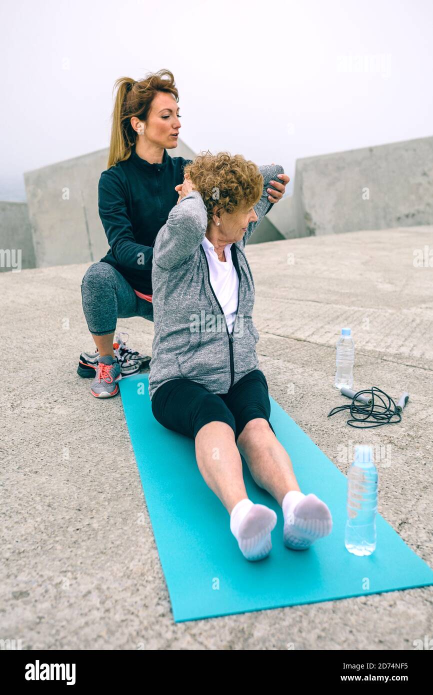 Young woman exercising with senior woman Stock Photo