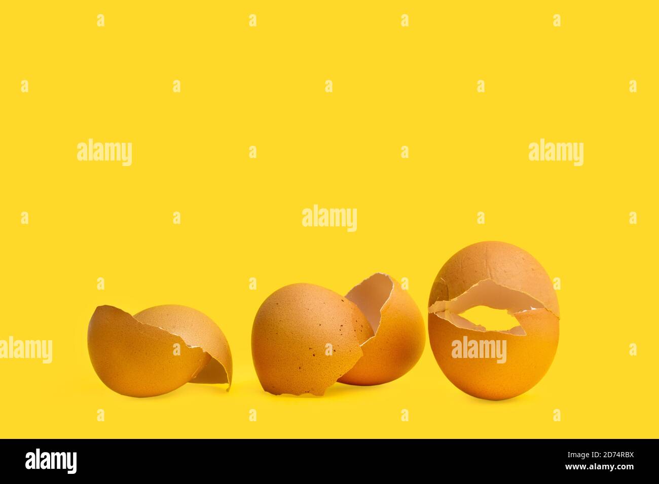 Cracked eggshells on a yellow background in a close up view Stock Photo