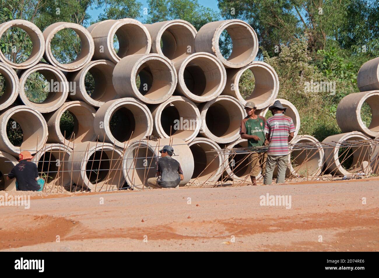 Sihanoukville, Cambodia - 30th December 2018 : View of a cambodian road construction site with workers on the street and many drainage concrete pipes Stock Photo