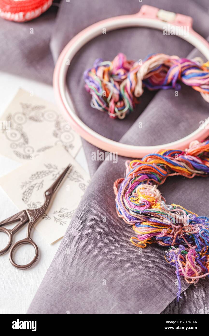 Set for embroidery. Linen fabric, patterns for embroidery, hoop, thread of different colors and needles. Copy space, top view Stock Photo