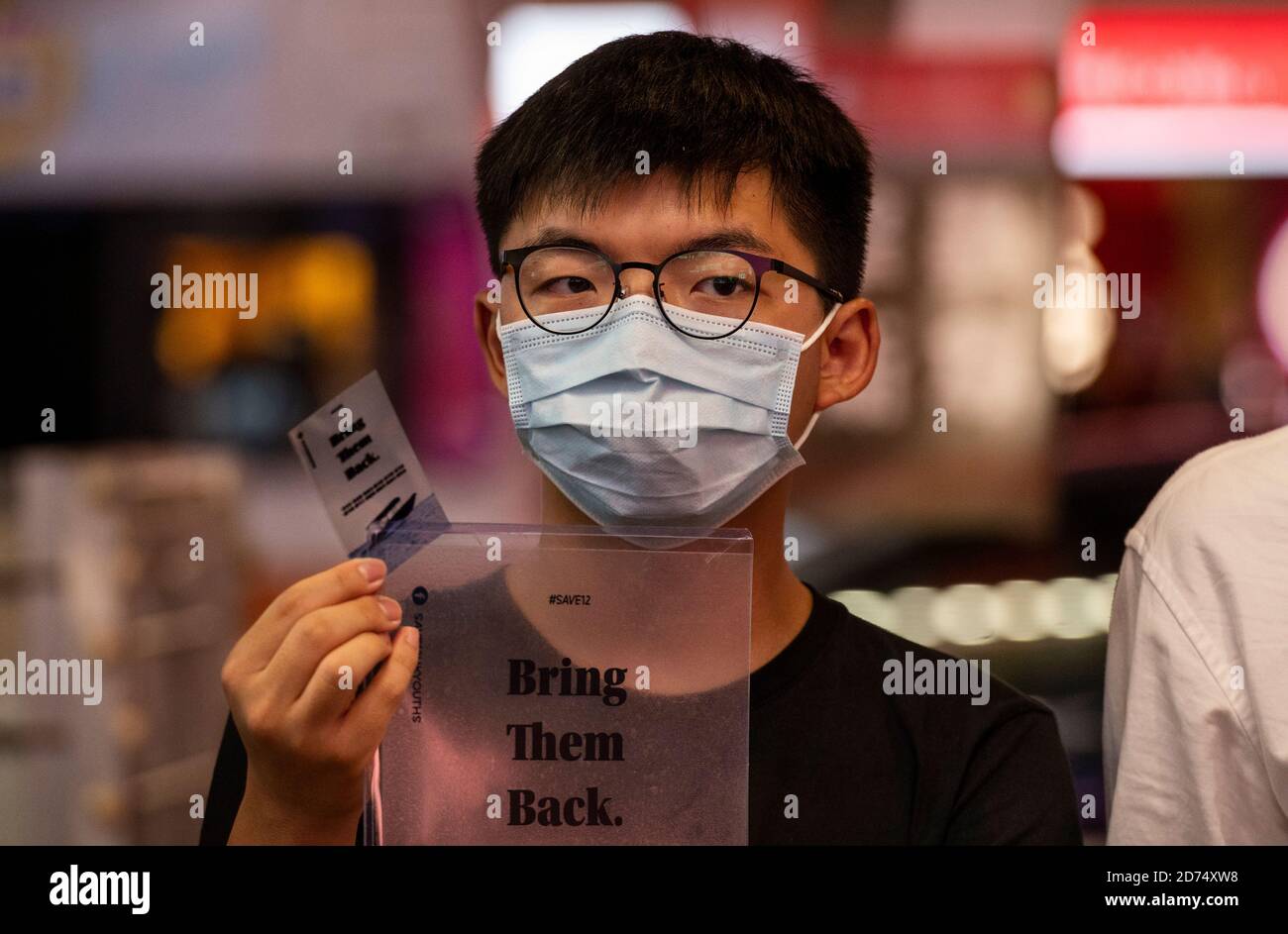 Pro-democracy activist Joshua Wong holds a leaflet in support of the 12 activists detained in Mainland China during the rally.Pro democracy activates rally in Hong Kong in support of the 12 Hongkongers detained in Mainland China after allegedly trying to flee to Taiwan to claim political asylum in August 2020. The 12 detainees has committed different political crimes in Hong Kong and were on court bail when they fled. Stock Photo