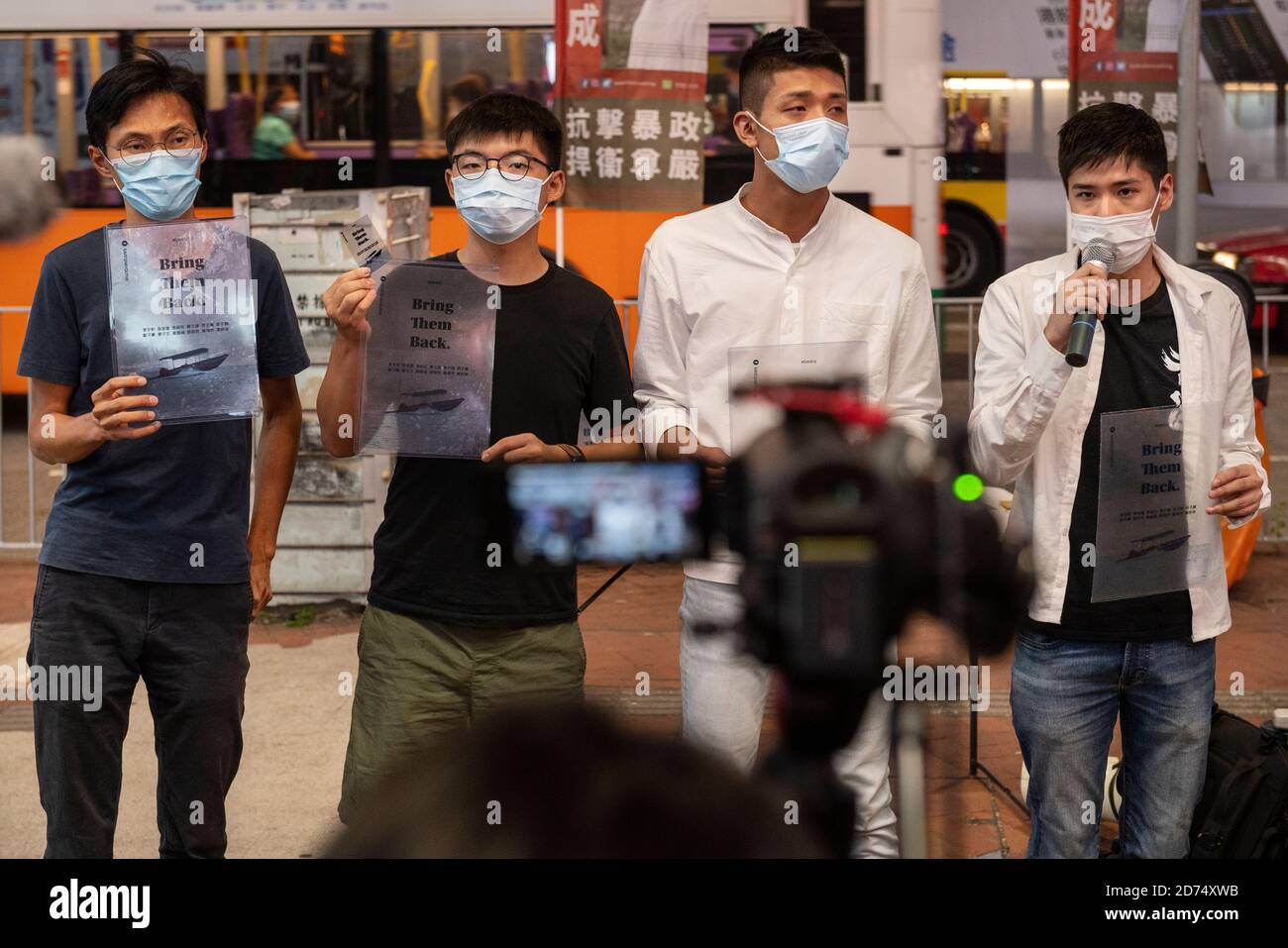 Pro-democracy activists Eddie Chu (L), Joshua Wong (L2), Owen Chow (R2), and Lester Shum (R) distribute leaflets while talking to the press in support of the 12 activists detained in Mainland China during the rally.Pro democracy activates rally in Hong Kong in support of the 12 Hongkongers detained in Mainland China after allegedly trying to flee to Taiwan to claim political asylum in August 2020. The 12 detainees has committed different political crimes in Hong Kong and were on court bail when they fled. Stock Photo