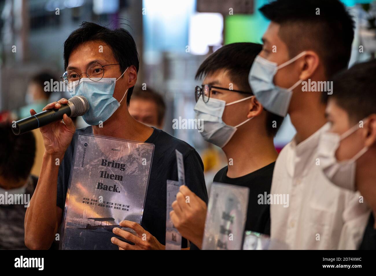 Pro-democracy activists Eddie Chu (L), Joshua Wong (L2), Owen Chow (R2), and Lester Shum (R) distribute leaflets while talking to the press in support of the 12 activists detained in Mainland China during the rally.Pro democracy activates rally in Hong Kong in support of the 12 Hongkongers detained in Mainland China after allegedly trying to flee to Taiwan to claim political asylum in August 2020. The 12 detainees has committed different political crimes in Hong Kong and were on court bail when they fled. Stock Photo