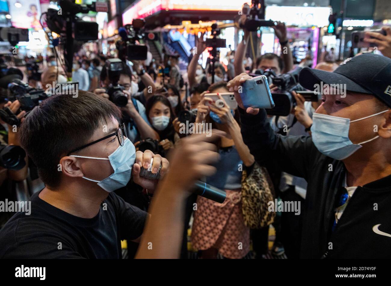 Pro-democracy activist Joshua Wong argues with a pro Chinese government man while he was distributing leaflets in support of the 12 activists detained in Mainland China during the rally.Pro democracy activates rally in Hong Kong in support of the 12 Hongkongers detained in Mainland China after allegedly trying to flee to Taiwan to claim political asylum in August 2020. The 12 detainees has committed different political crimes in Hong Kong and were on court bail when they fled. Stock Photo