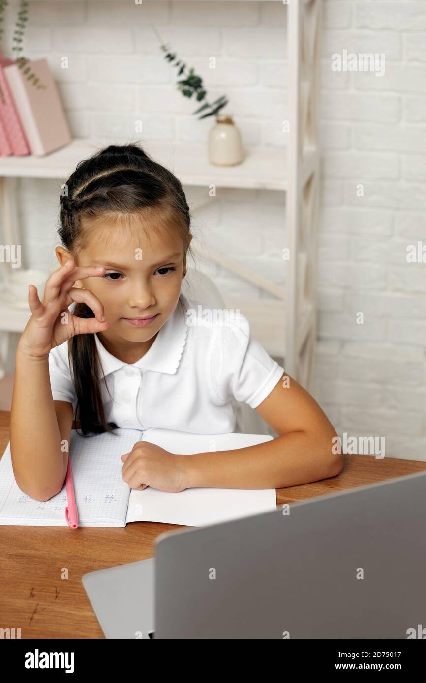 happy little child girl using laptop computer for studying online e ...