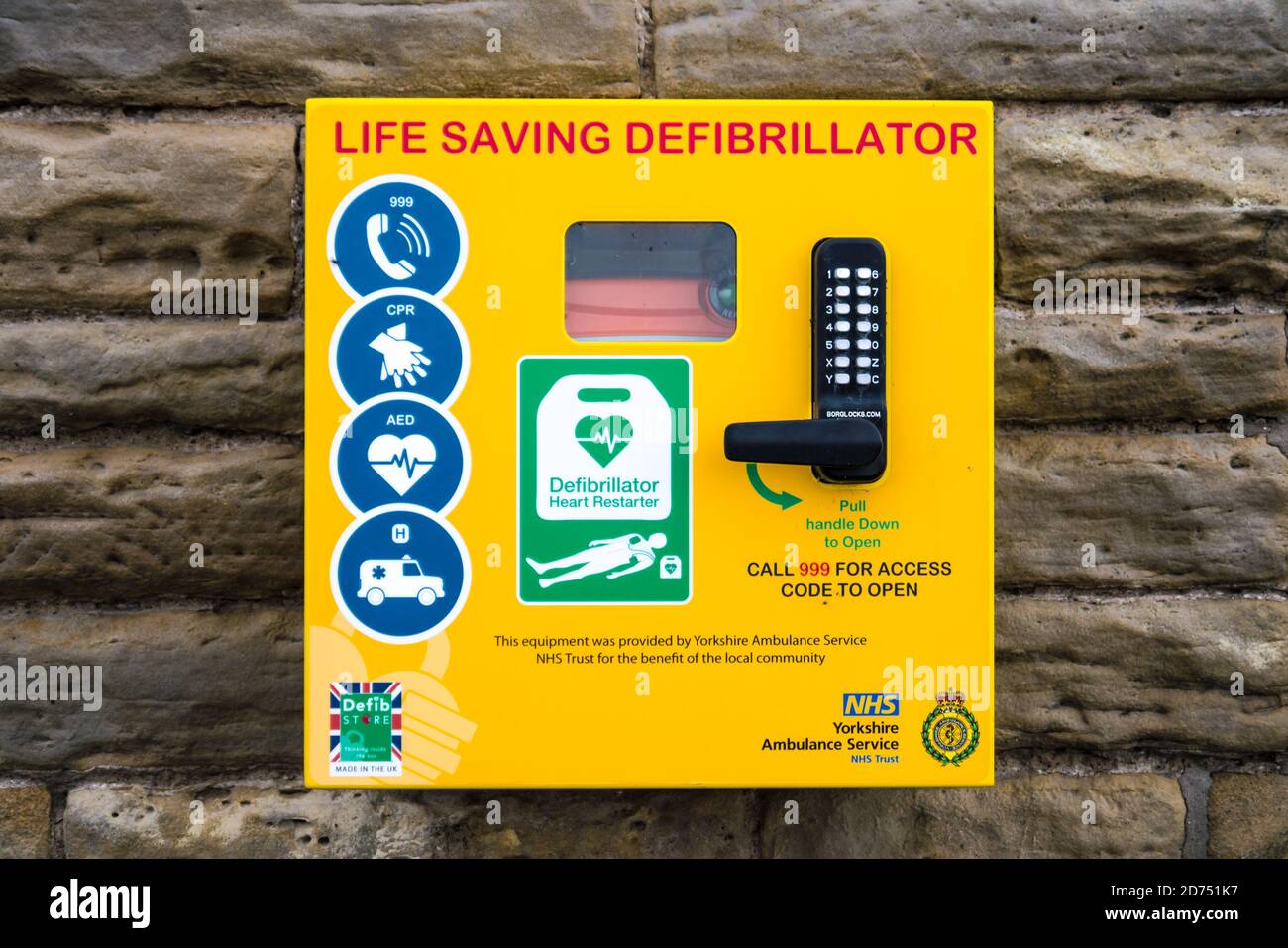 A Life Saving Defribilator Attached to a Stone Wall in a Yorkshire Village Stock Photo
