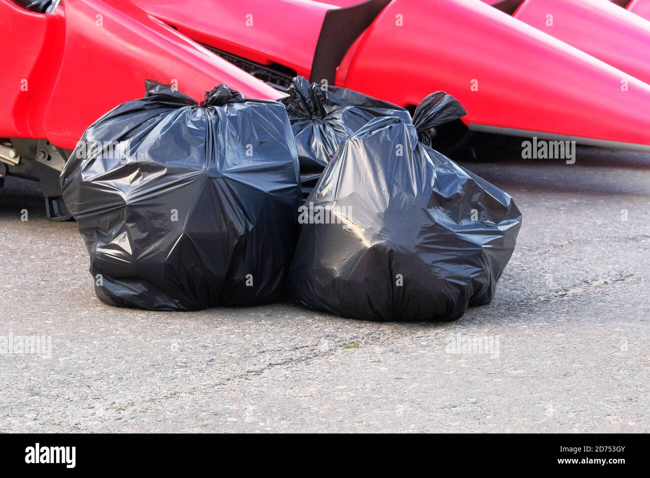 Garbage plastic black bags waste at walkway community village. Plastic bags of waste. Stock Photo