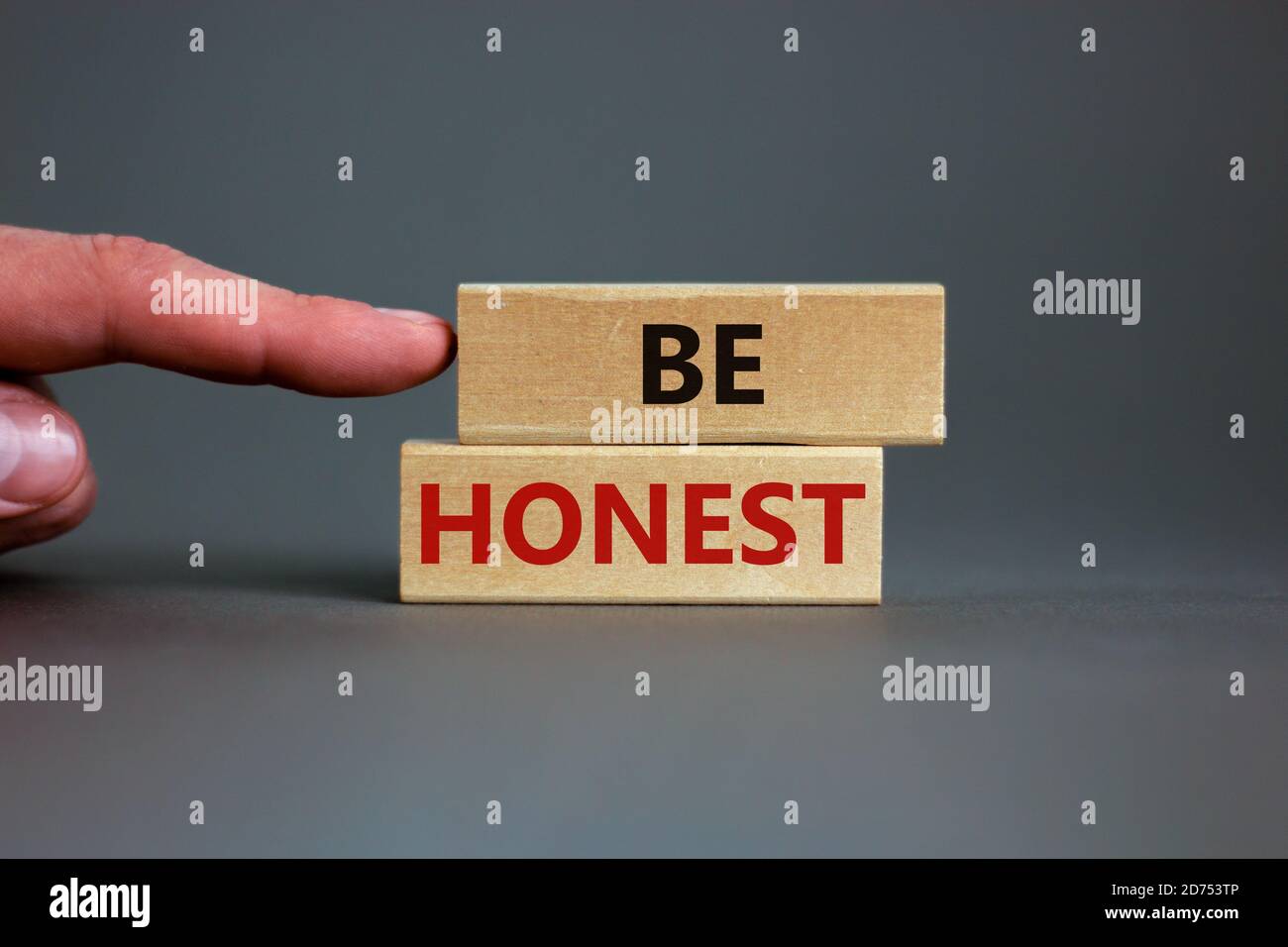 Wooden blocks with the text 'be honest' on beautiful grey background ...