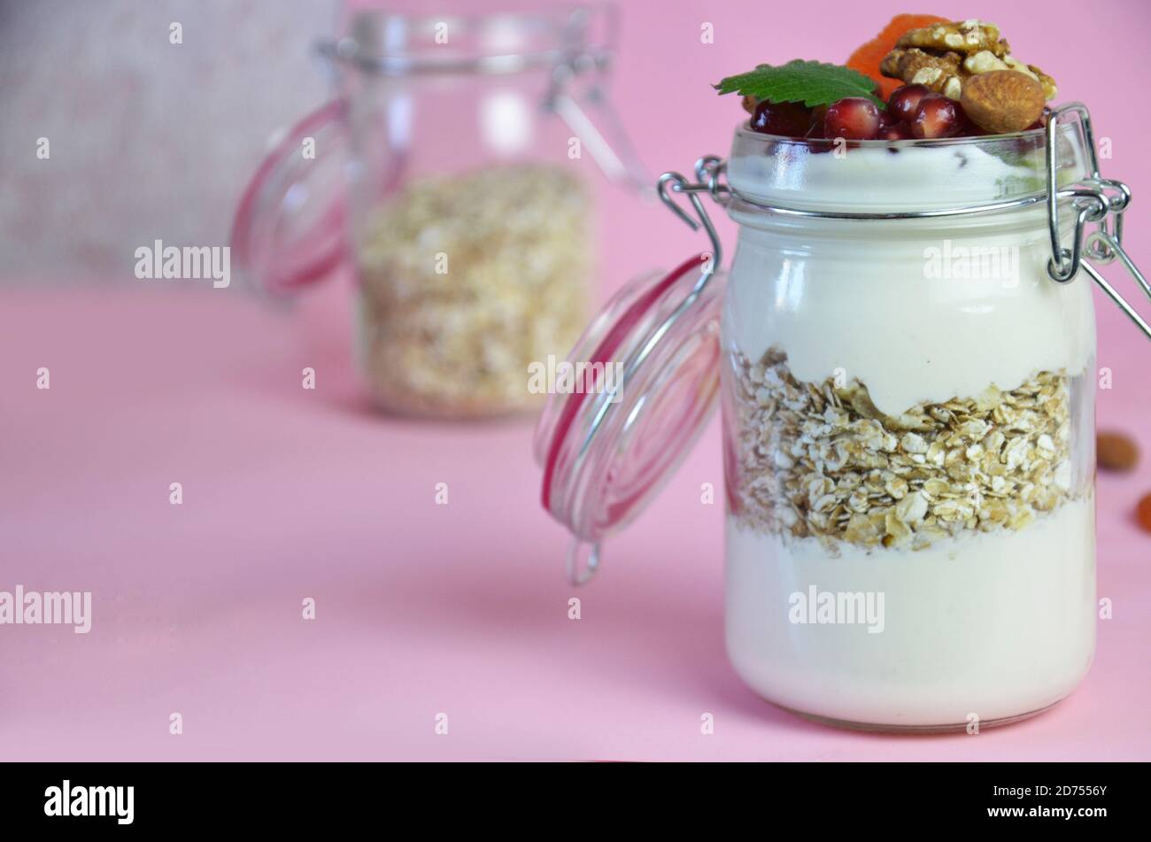 Healthy breakfast overnight oats with fresh berries in a glass jar with dried fruits, apple and nuts, walnuts, almonds. with yogurt, cottage cheese, p Stock Photo