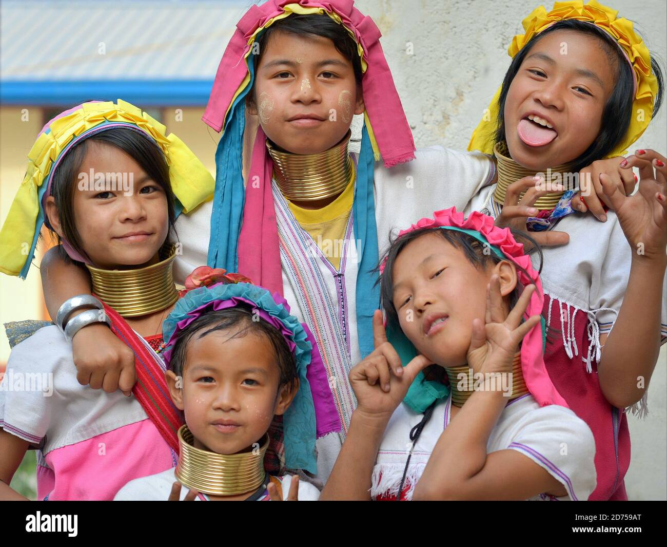 Five boisterous Myanmarese Kayan Lahwi long neck girls with polished tribal brass neck rings pull faces for the camera. Stock Photo