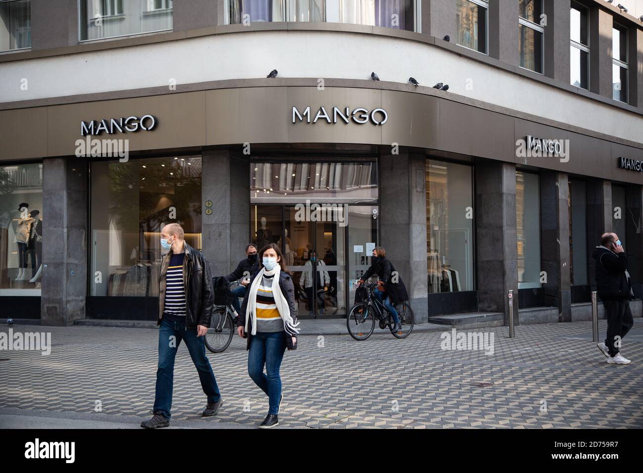 People wearing face masks walk past the Spanish fashion clothing company  Mango store in Ljubljana after Slovenia redeclared an epidemic.As daily new  covid-19 cases passed twenty percent of all tested Slovenia declared
