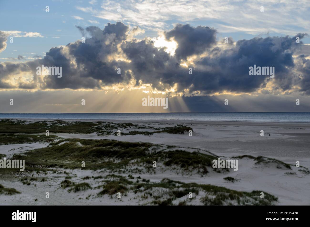 Amrum island, Germany: sun rays emerging through the dark storm clouds ...