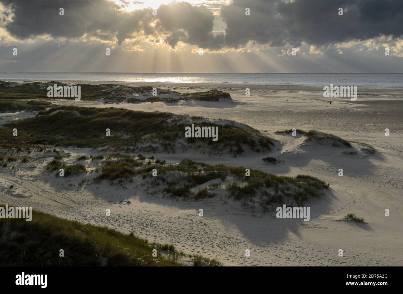 Amrum island, Germany: sun rays emerging through the dark storm clouds ...