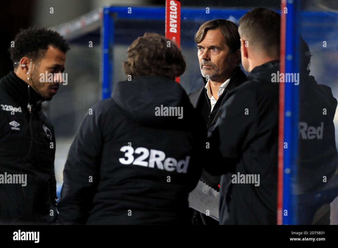 Derby County manager Phillip Cocu (centre) speaks to his staff members during the Sky Bet Championship match at The John Smith's Stadium, Huddersfield. Stock Photo