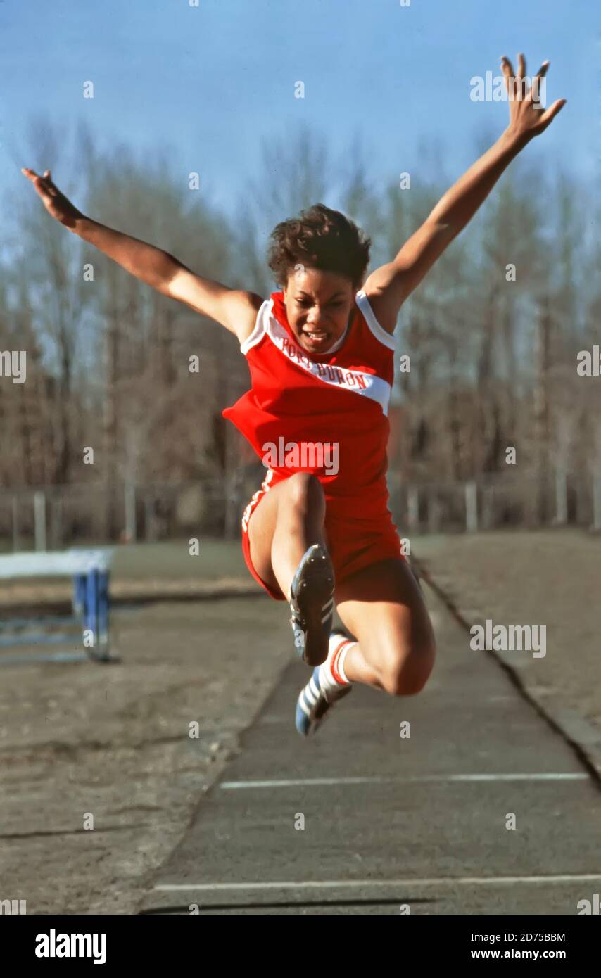 Black female long jumper competesin a high school track meet long jump contest Stock Photo