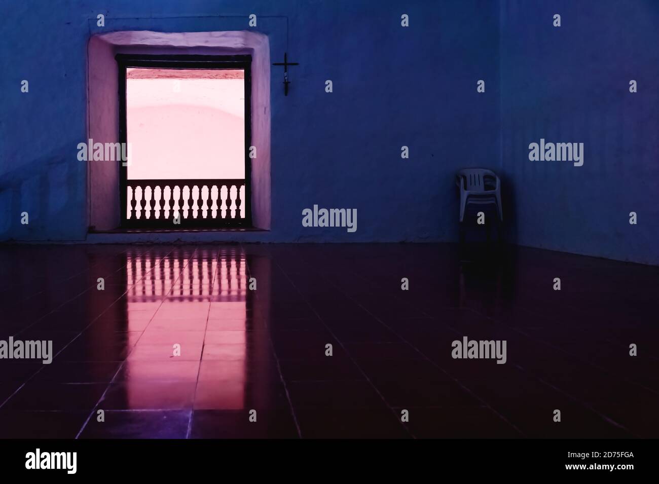 Dark room with seats and cross and rose enlightened door openening the former monestary Convent de San Bernardino de Siena in Valladolid, Yucatan, Mex Stock Photo