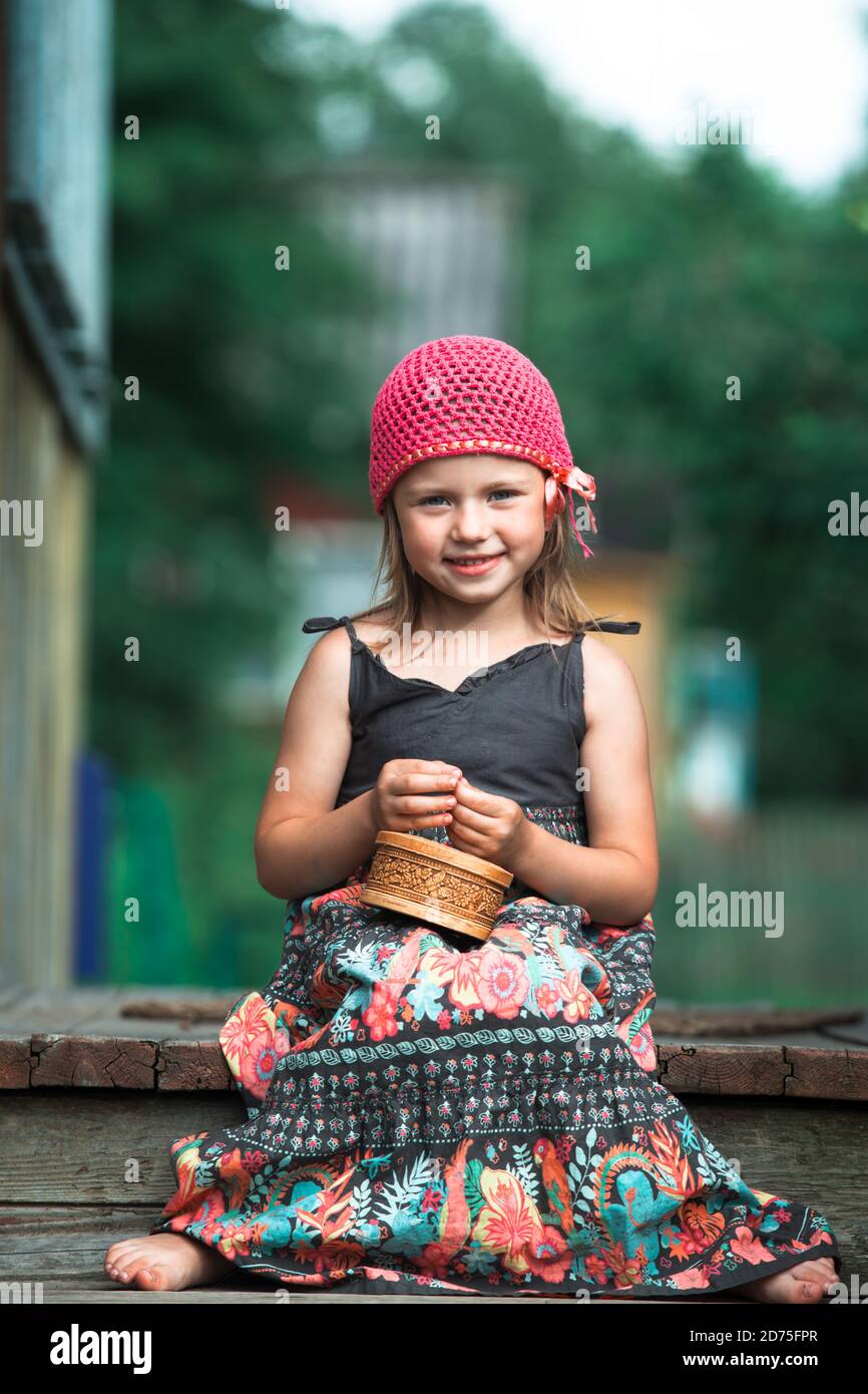 Little cute girl in national dress sitting outdoor in the village Stock ...