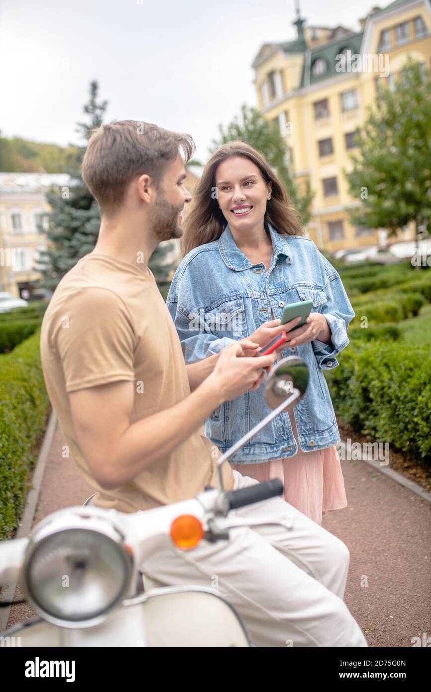 A couple using smartphones while walking together Stock Photo