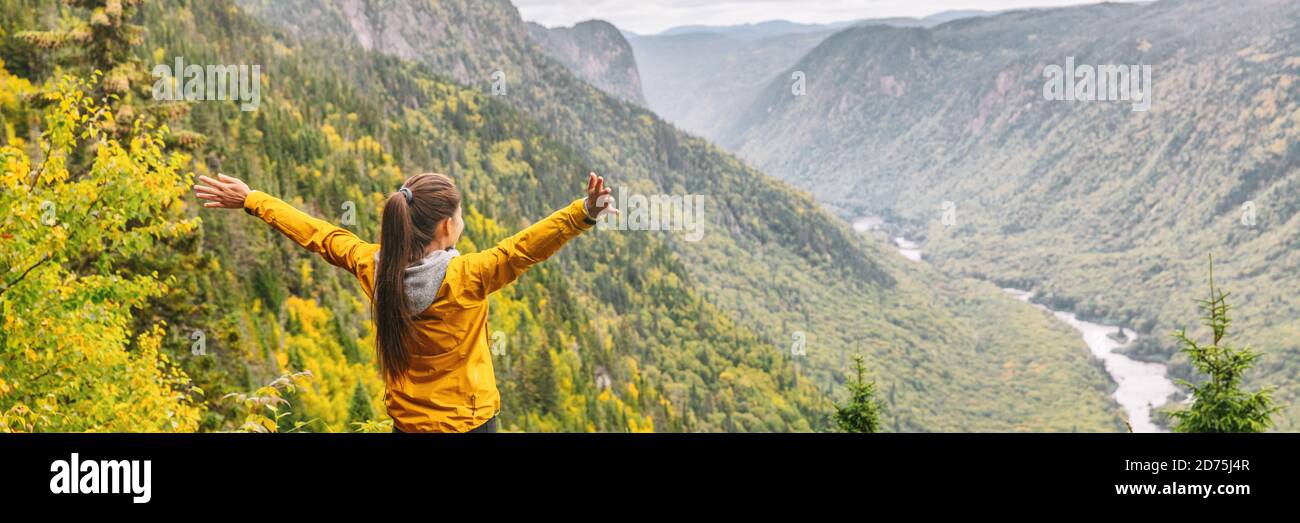 Happy hike travel woman with open arms outstretched in happiness carefree enjoying fall autumn panoramic banner background Stock Photo