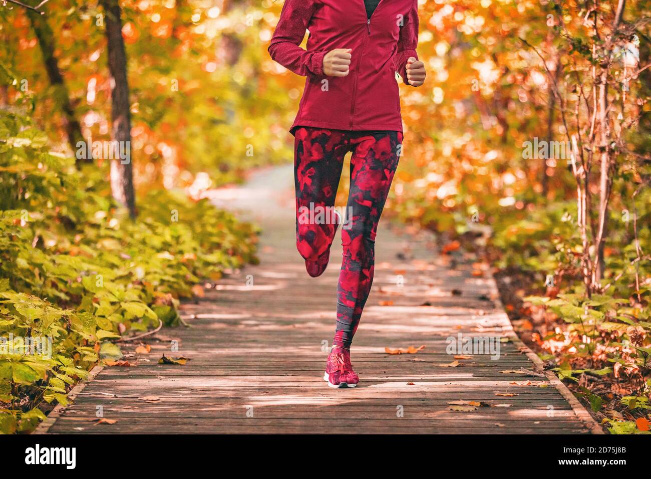 Woman runner in jogging outfit running on a street. Woman