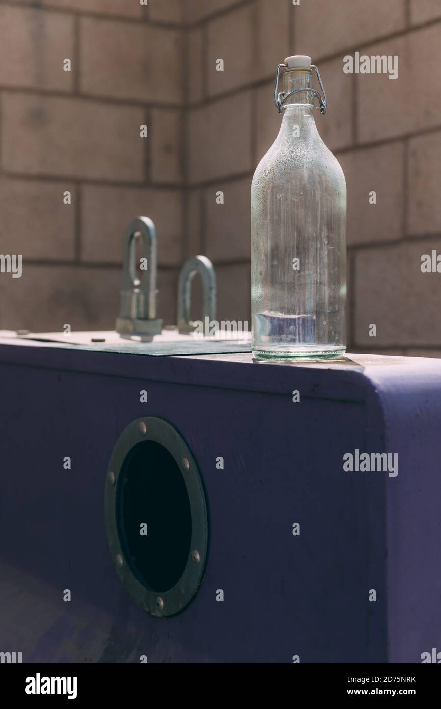 Glass bottle on the bottle trash can. Reducing waste by following the