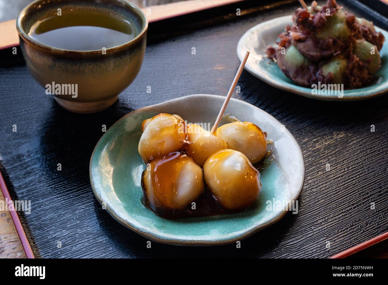 Dango, a type of Japanese sweet rice dumpling, next to green tea. Stock Photo