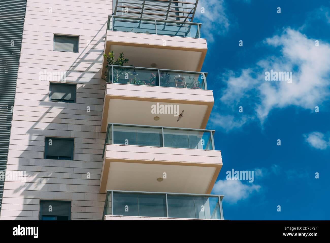 Balconies and blue sky with clouds. Part of a residential building in
