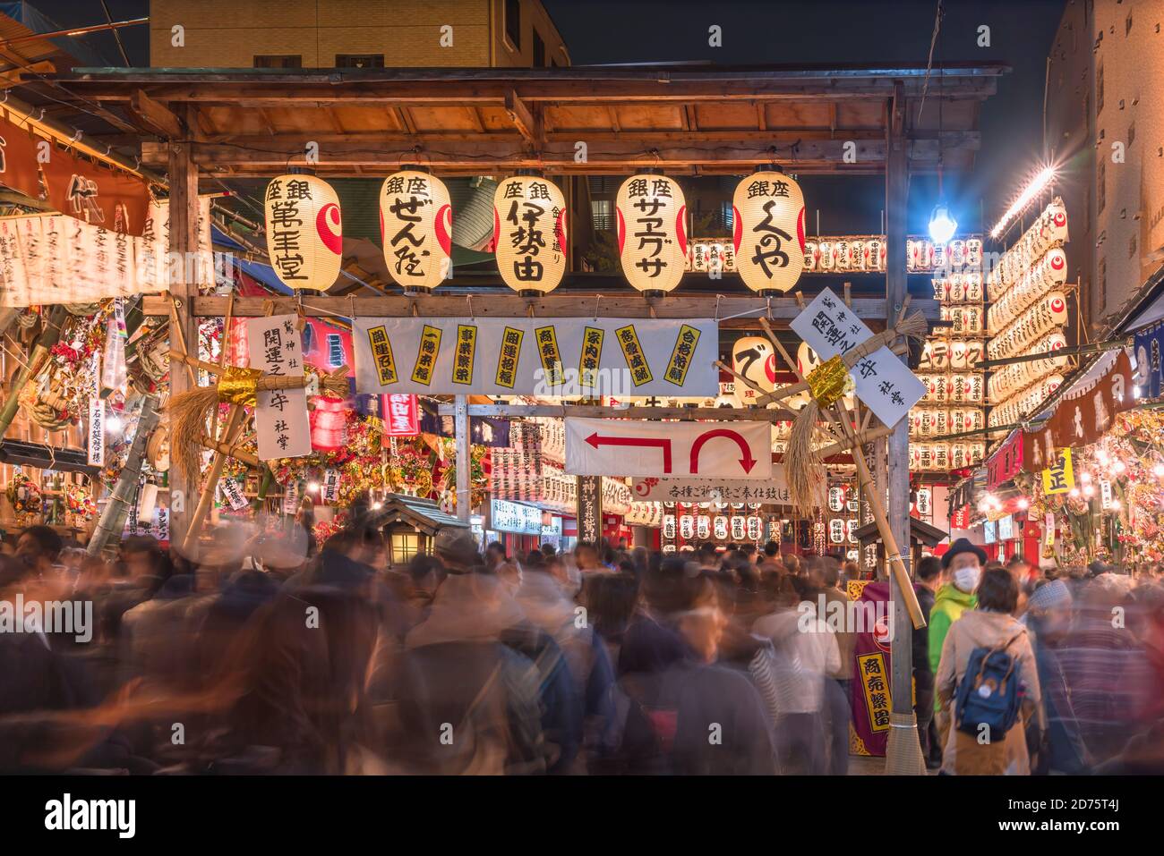 asakusa, japan - november 08 2019: Crowd passing through a gate of Tori-no-Ichi Fair decorated with luminous lanterns in Ootori shrine where traders b Stock Photo