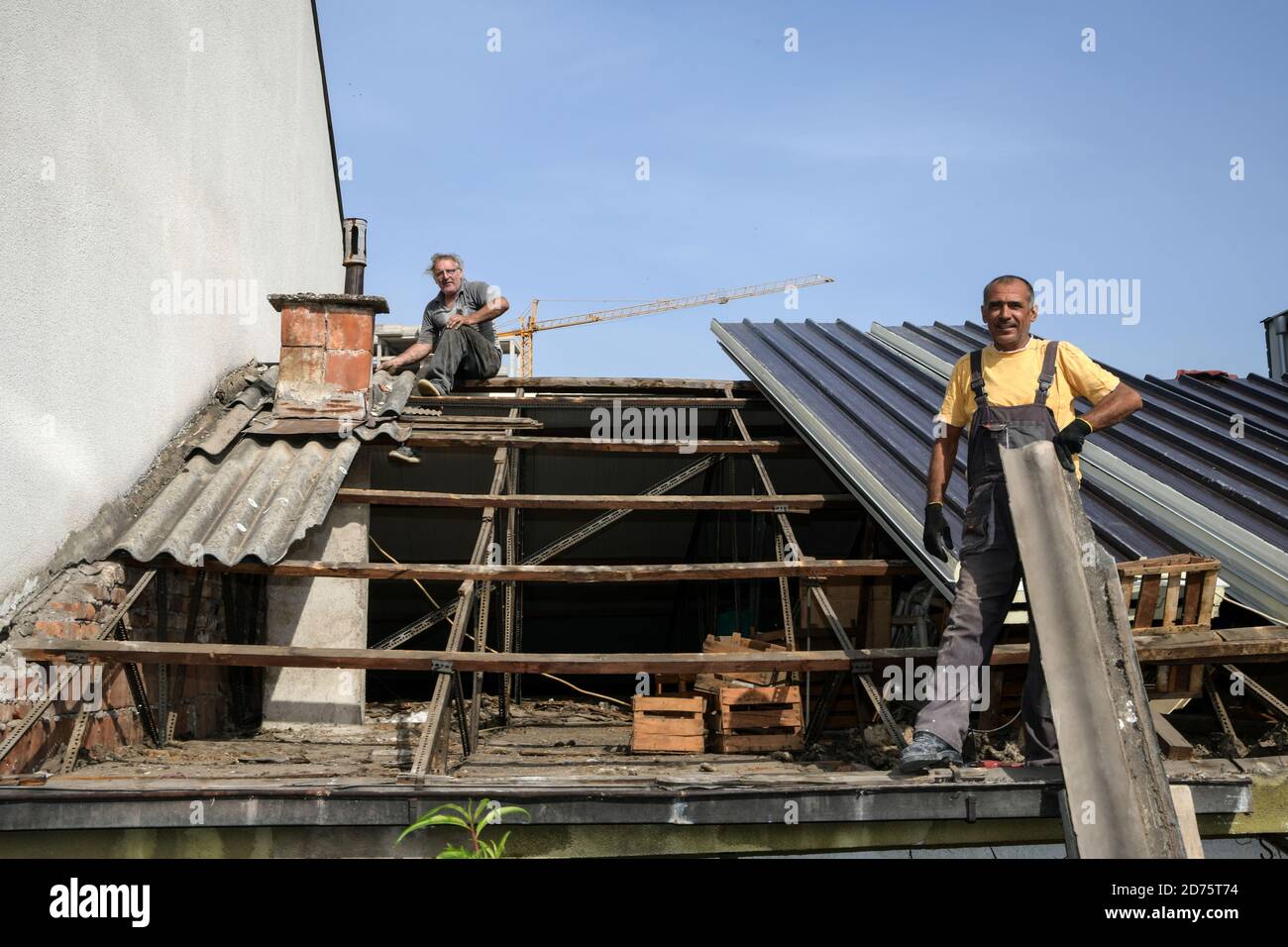 Two workers roofer builder working on roof structure on construction site Stock Photo