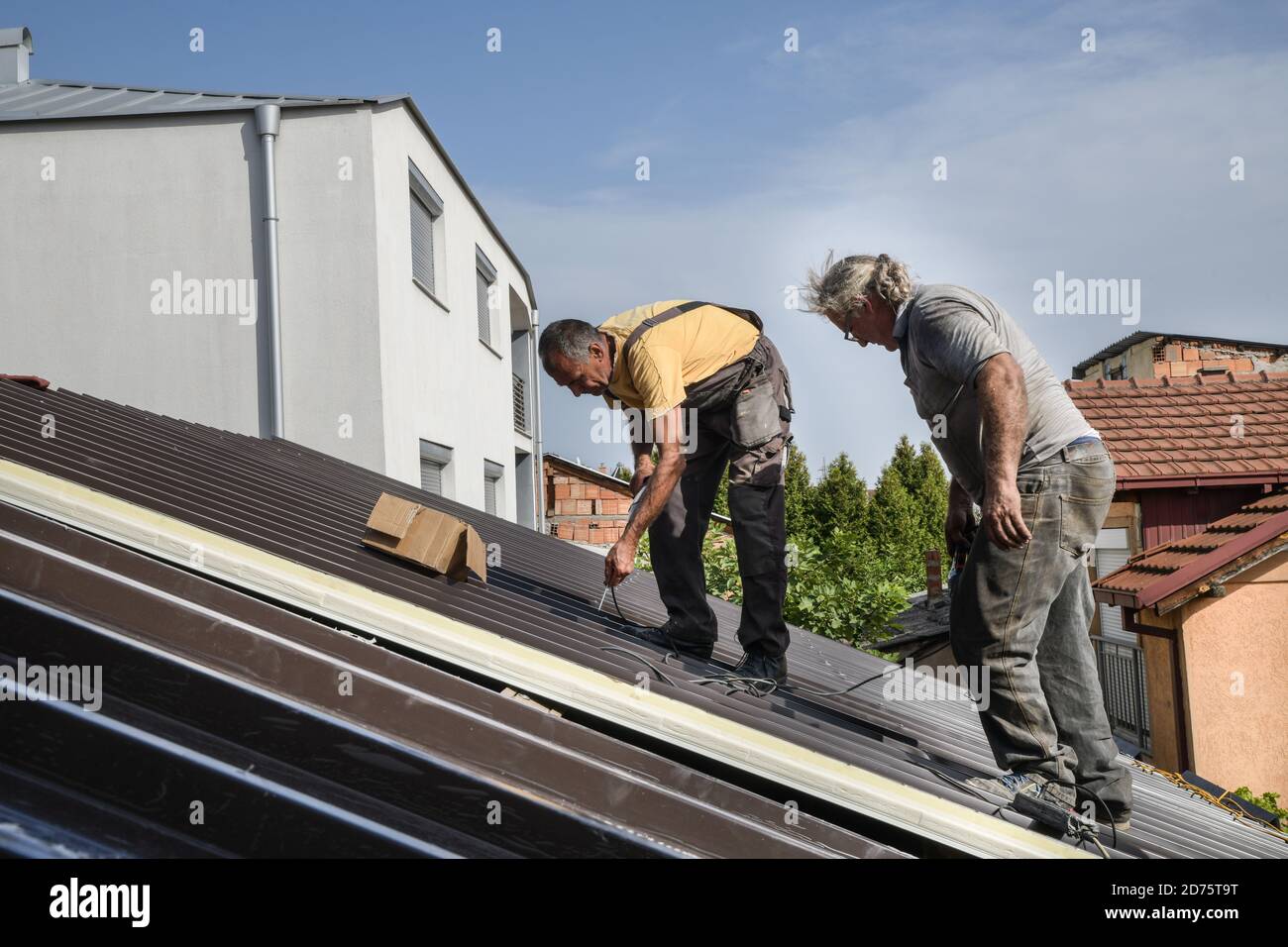 Two workers roofer builder working on roof structure on construction site Stock Photo