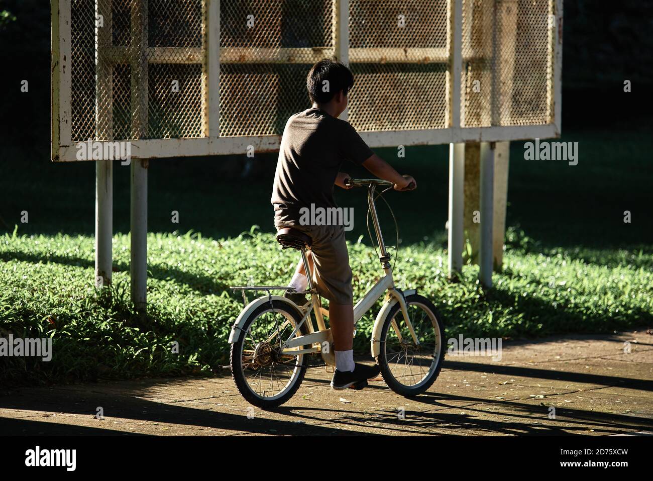 A boy riding a bicycle down the street Stock Photo