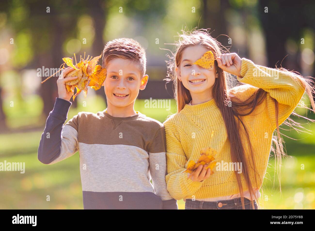 Happy Twins Teenagers Boy And Girl Posing Hugging Each Other In Autumn Park Holding Fallen Yellow Leaves In Hand In Sunny Weather Autumn Season Theme Stock Photo Alamy