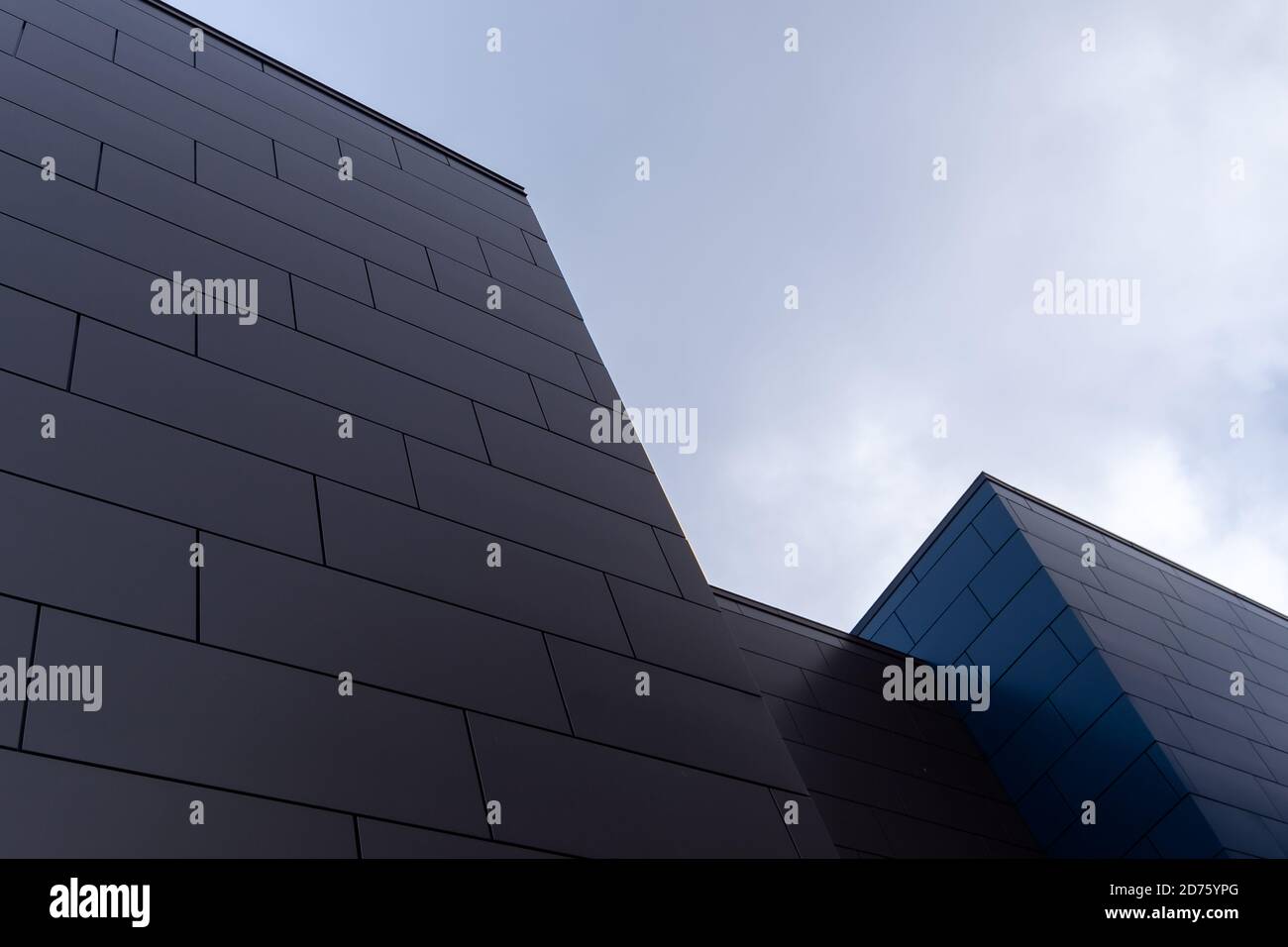 Beige and blue exterior walls of a modern aluminum business building with oblong metal composite panels. Stock Photo