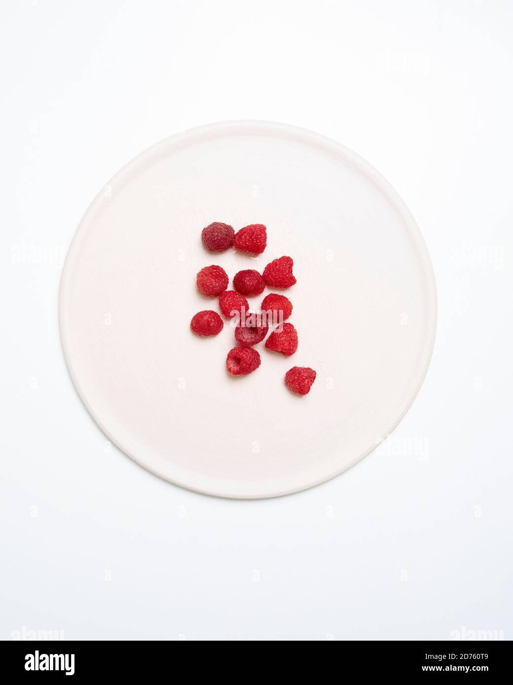 High Angle View of Raspberries on Round White Plate Stock Photo