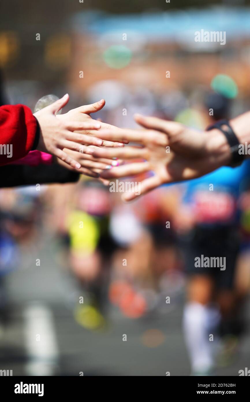 Kids give a high five to Boston Marathon runners Stock Photo - Alamy