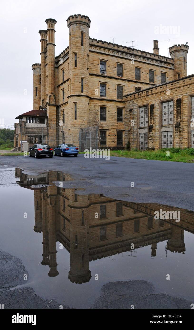 The imposing facade of the Old Joliet Prison is reflected in a puddle. The historic site opened in 1858, operated until 2002 and is now open for tours. Stock Photo