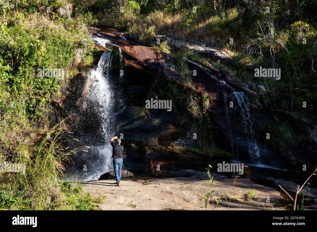 Wide shot of Mato Limpo waterfall with his green vegetation and clear water splashing over the rock formations. Cunha, Sao Paulo - Brazil. Stock Photo