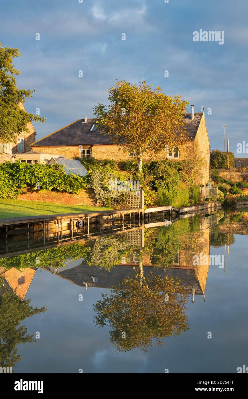House reflecting in the oxford canal on an autumn morning at sunrise. Twyford Wharf, Kings Sutton, Oxfordshire / Northamptonshire border, England Stock Photo