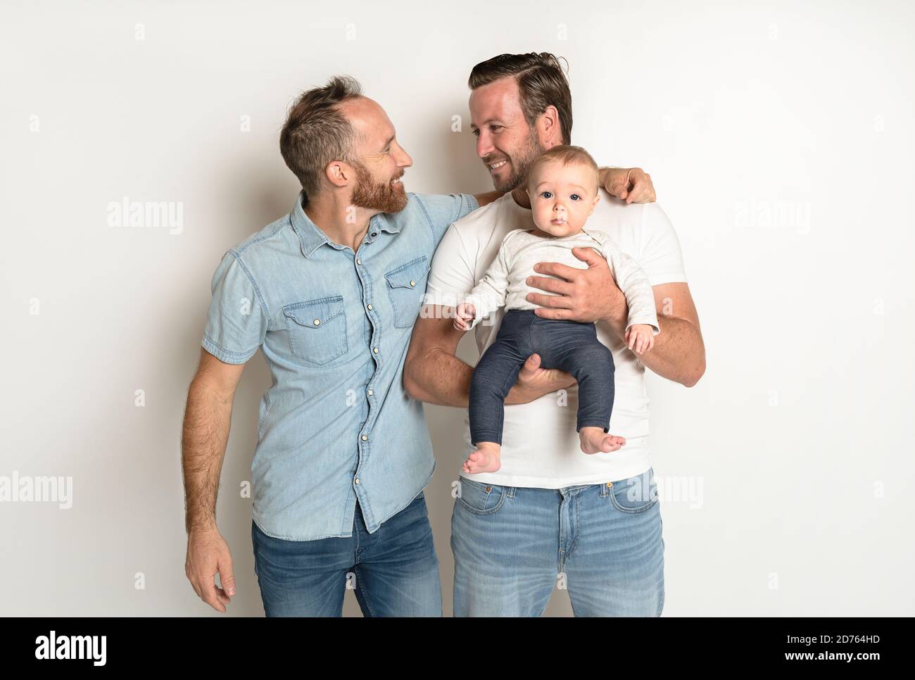 Two male gay couple with adopted child. Homosexual Couple holding hands  LGBT flag. Concept LGBT family. kids drawing pencils Stock Photo