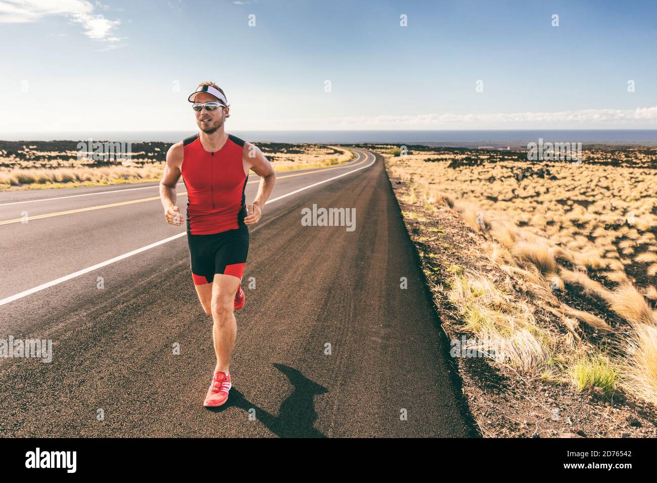 Triathlon man athlete running in tri suit training Stock Photo Alamy