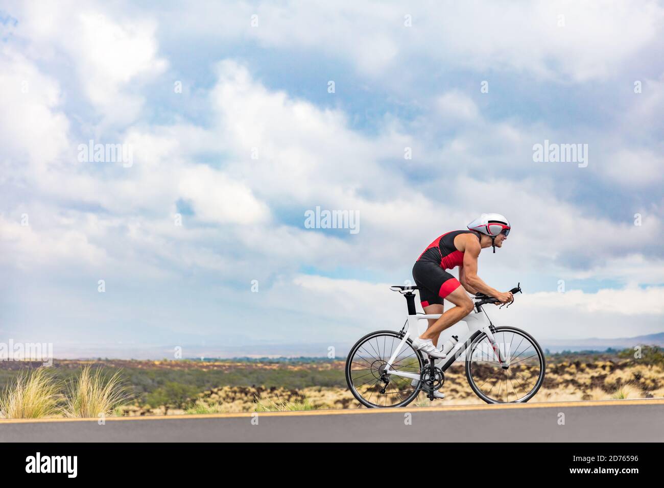 Triathlon cyclist biking on road bike on ironman competition racing against time on nature