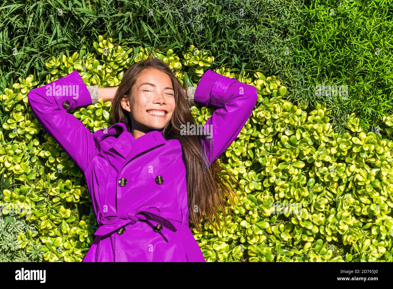 Happy spring girl lying on green grass texture background. Asian woman ...