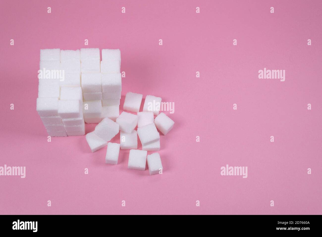 White sugar cubes on pink background composition. Stock Photo