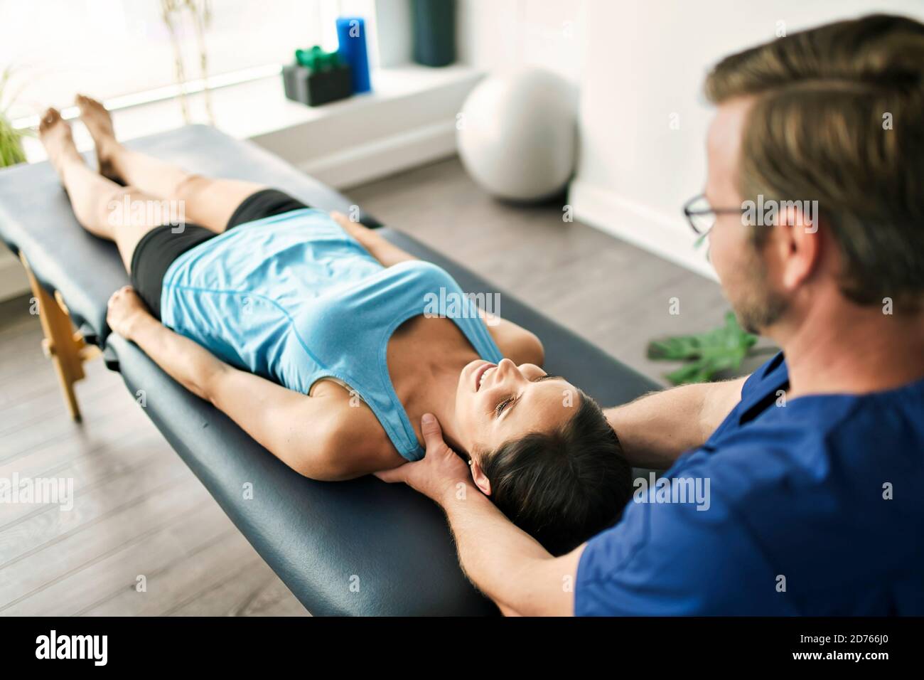 Male Physical Therapist Stretching a Female Patient neck Stock Photo