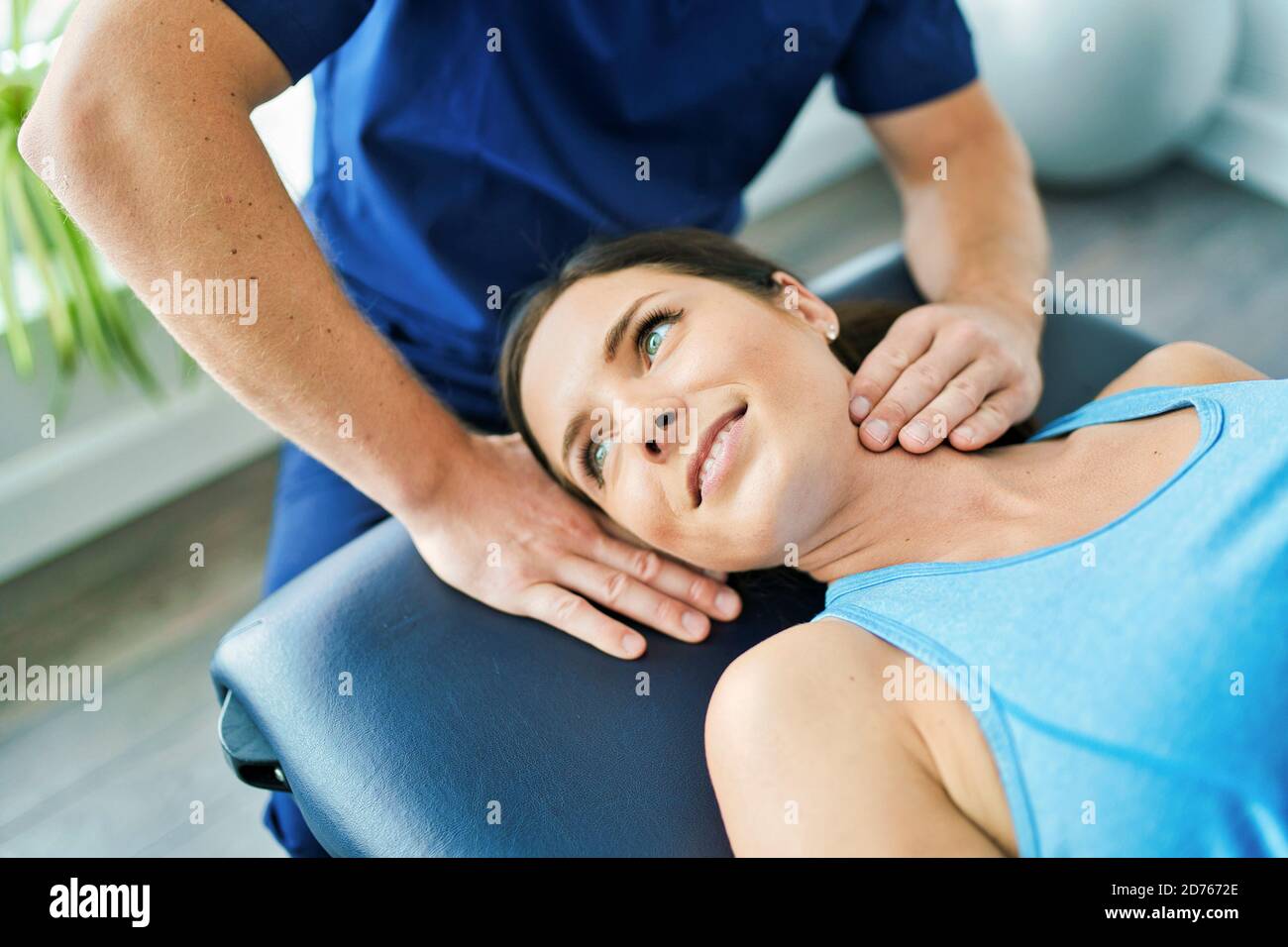 Male Physical Therapist Stretching a Female Patient neck Stock Photo