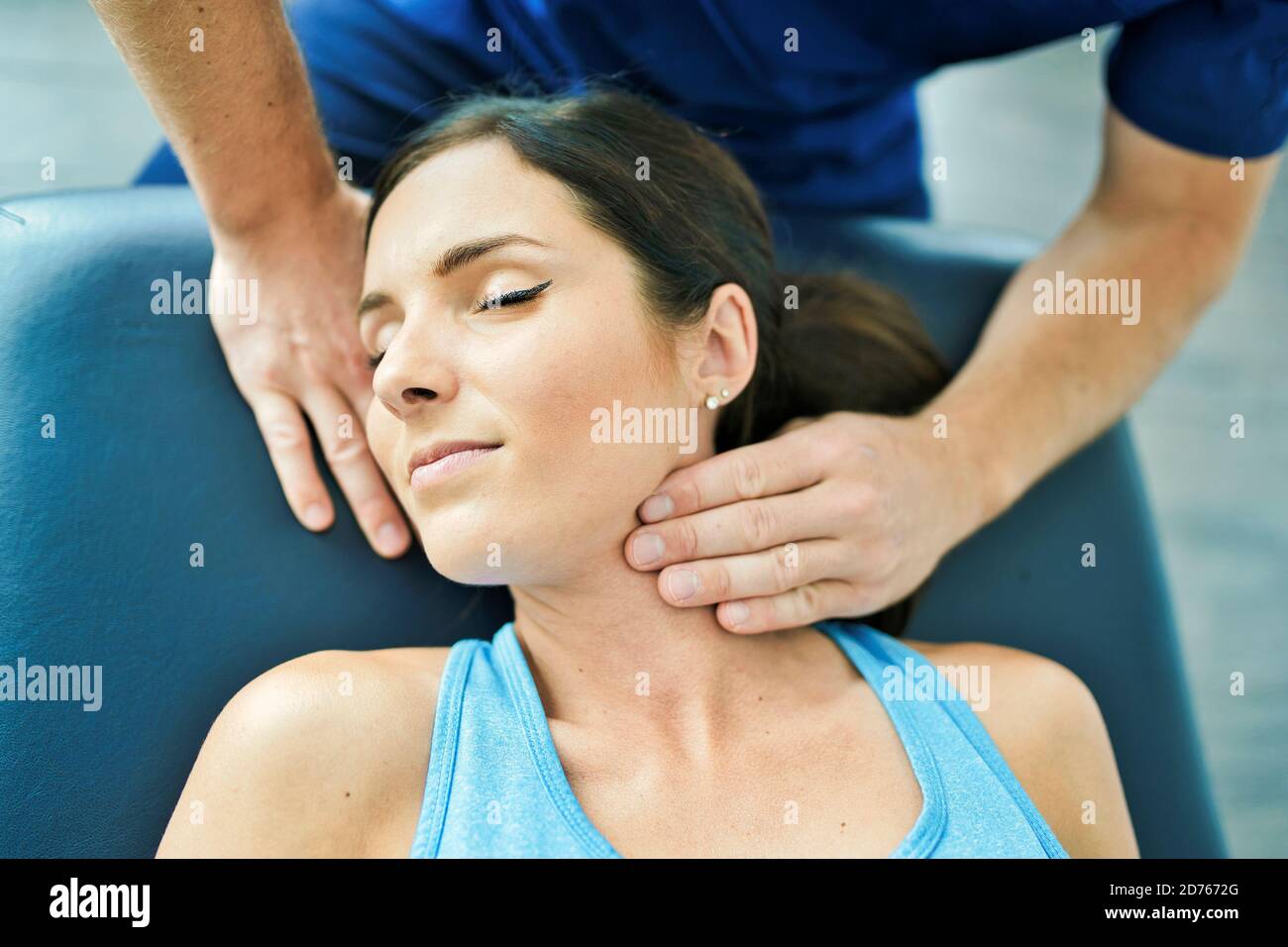 Male Physical Therapist Stretching a Female Patient neck Stock Photo