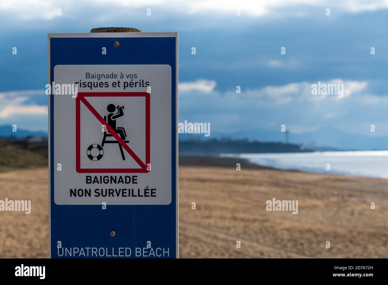 Warning sign written in French indicating "unpatrolled beach" on the