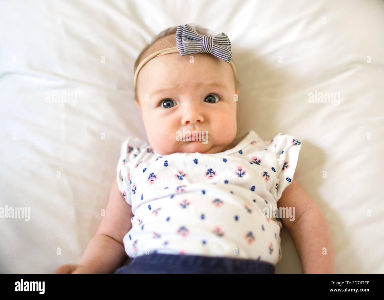 happy newborn baby on the bed wearing cute clothes Stock Photo Alamy