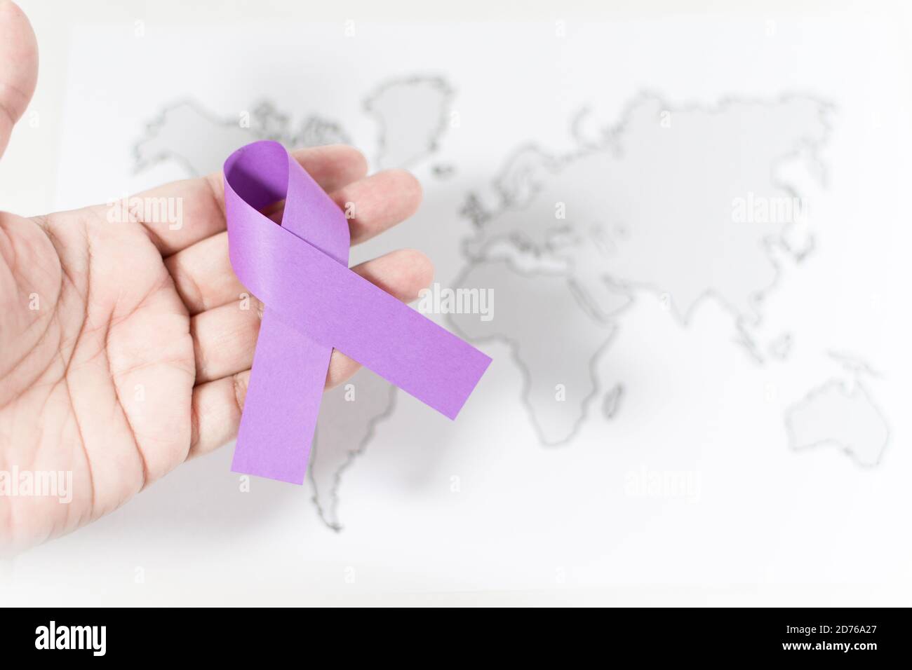 Purple ribbon on a person's hand - awareness of violence against women ...